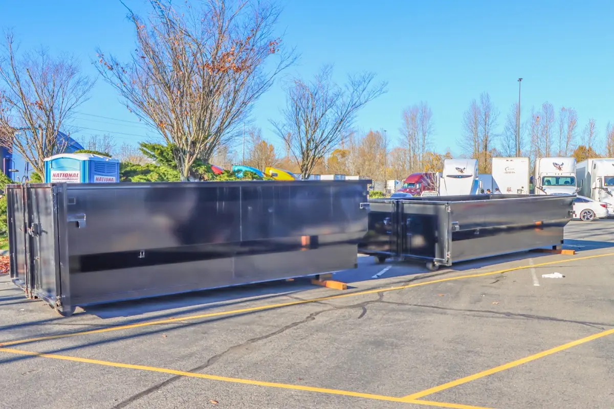 Professional dumpster rental service with roll-off container on residential driveway in East Ridge